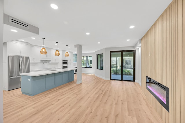 kitchen featuring appliances with stainless steel finishes, recessed lighting, light countertops, and light wood finished floors