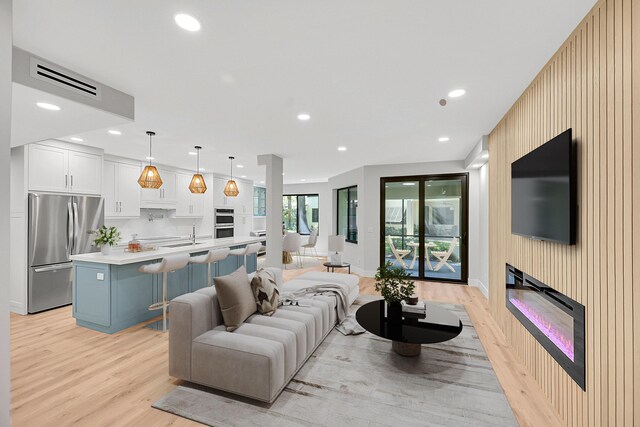 303 Sea Oats Dr Unit D, Juno Beach, FL 33408 - living room with light wood finished floors, recessed lighting, a glass covered fireplace, and baseboards