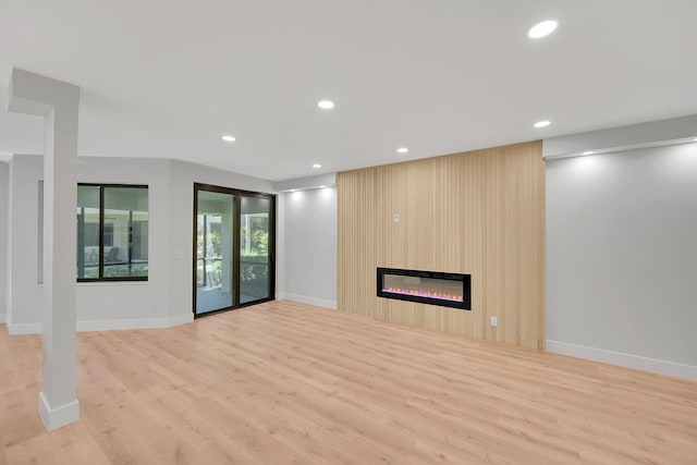 303 Sea Oats Dr Unit D, Juno Beach, FL 33408 - unfurnished living room featuring wood finished floors, a large fireplace, recessed lighting, and baseboards