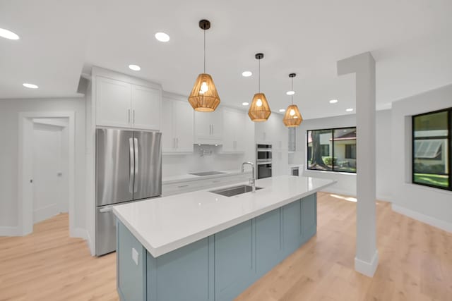 303 Sea Oats Dr Unit D, Juno Beach, FL 33408 - kitchen featuring appliances with stainless steel finishes, light countertops, white cabinetry, light wood-style floors, and recessed lighting