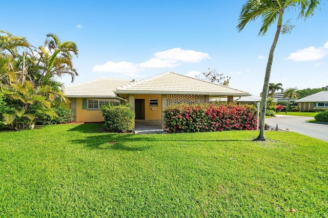 view of front of home featuring a front yard and a tile roof