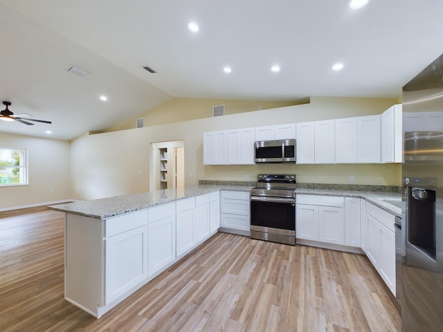 kitchen with a peninsula, visible vents, white cabinets, open floor plan, and appliances with stainless steel finishes