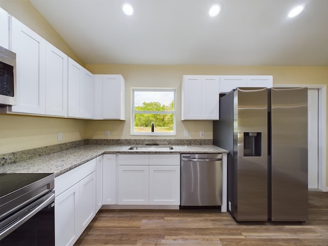 kitchen with white cabinets, light stone countertops, and stainless steel appliances