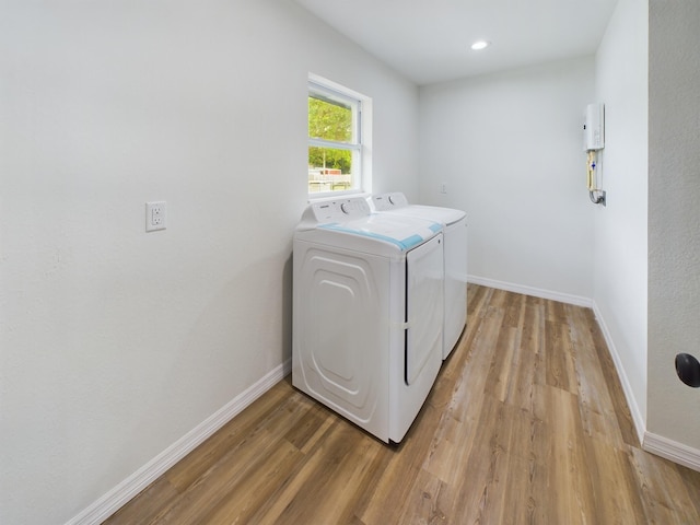 laundry area with recessed lighting, laundry area, baseboards, light wood-type flooring, and washer and clothes dryer