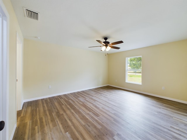 empty room with light wood-type flooring, baseboards, visible vents, and a ceiling fan