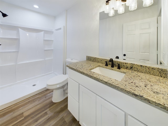 full bath with a stall shower, vanity, toilet, and wood finished floors