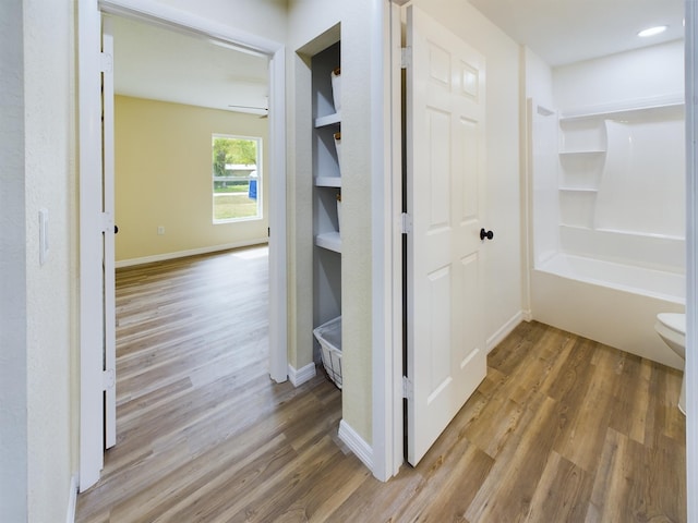 hallway featuring baseboards and wood finished floors