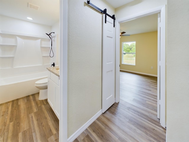 bathroom featuring visible vents, shower / bathing tub combination, toilet, wood finished floors, and baseboards