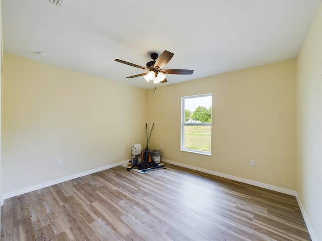 empty room with light wood-style flooring, baseboards, and a ceiling fan