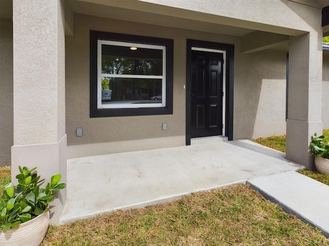 view of exterior entry with stucco siding