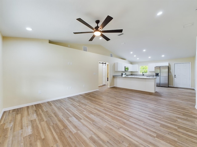 unfurnished living room with light wood-style floors, visible vents, vaulted ceiling, and a ceiling fan