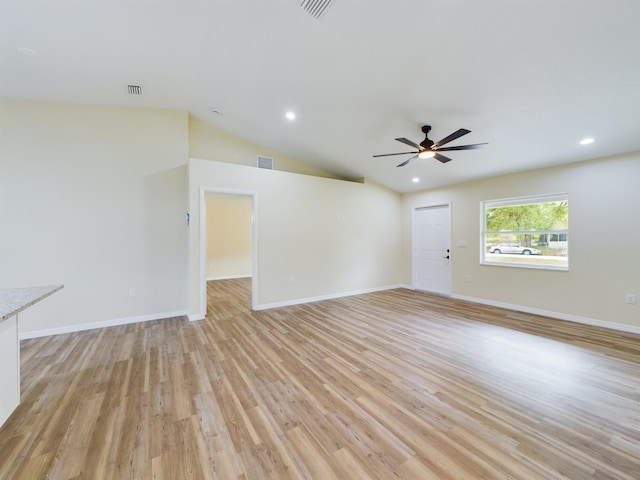 spare room featuring lofted ceiling, baseboards, visible vents, and light wood-style floors