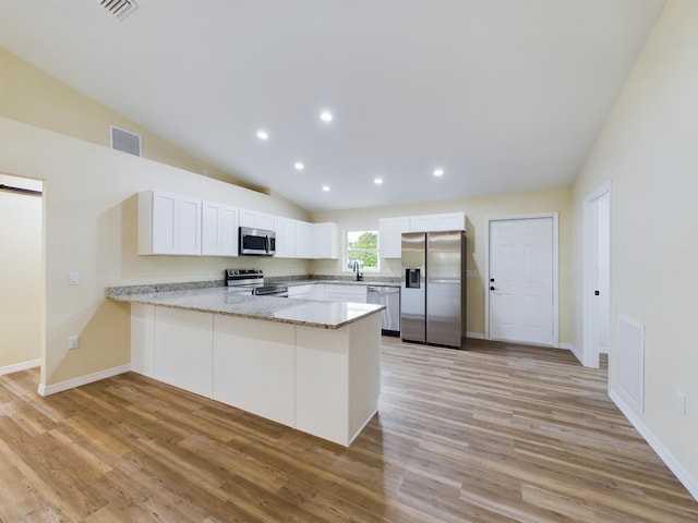 kitchen with light wood-style flooring, a peninsula, visible vents, white cabinets, and appliances with stainless steel finishes