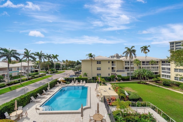 pool featuring a residential view, a patio, and a lawn