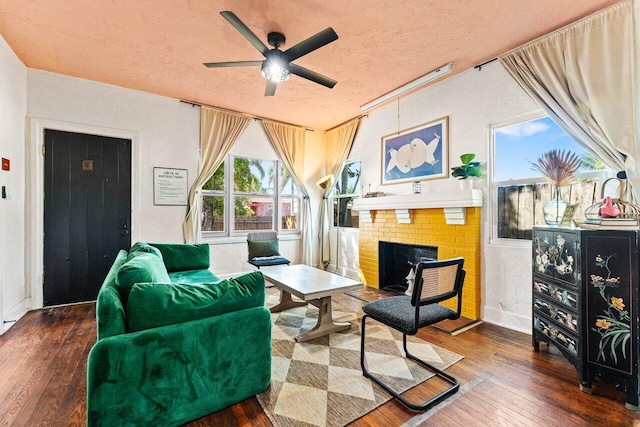 interior space with a ceiling fan, a fireplace, a textured ceiling, and hardwood / wood-style flooring