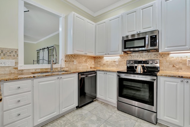 kitchen featuring ornamental molding, stainless steel appliances, and white cabinetry