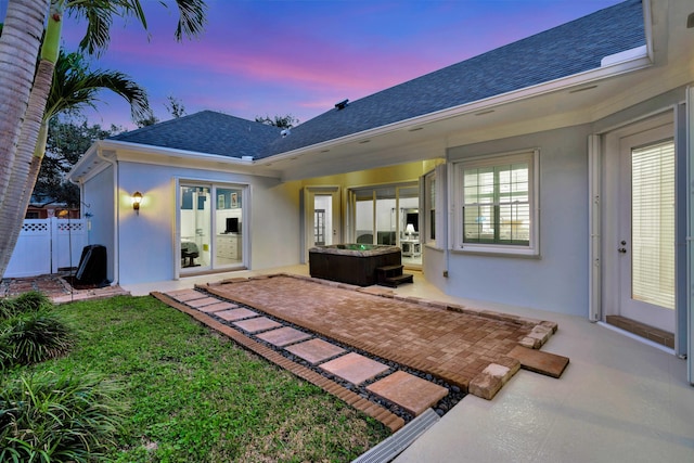 back house at dusk with a patio area