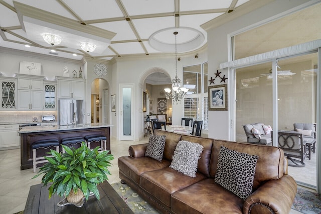 living room with crown molding, arched walkways, a notable chandelier, and light tile patterned floors