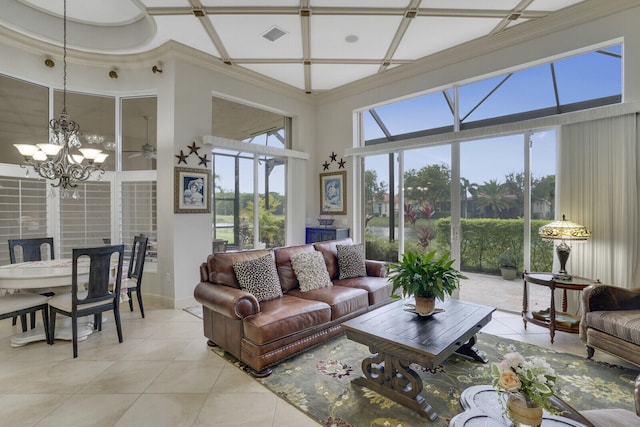 living room with light tile patterned flooring, visible vents, a towering ceiling, an inviting chandelier, and crown molding