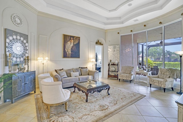 living area featuring a towering ceiling, light tile patterned floors, and a raised ceiling