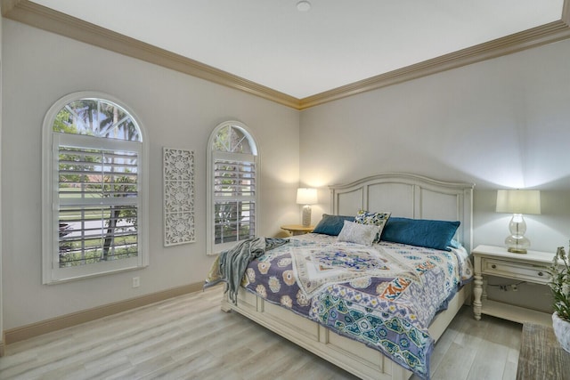 bedroom featuring light wood-type flooring, baseboards, and crown molding