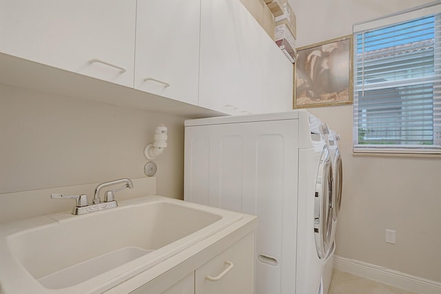 washroom with washer and dryer, cabinet space, a sink, and baseboards