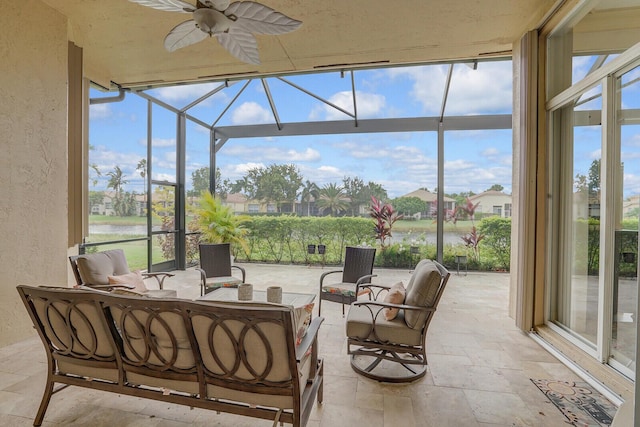 sunroom / solarium with ceiling fan and a water view