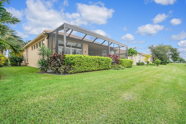 exterior space featuring glass enclosure, stucco siding, and a yard