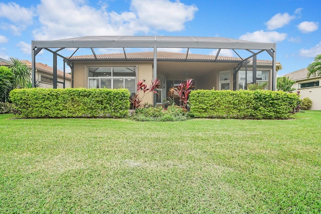 back of property featuring a lawn, a lanai, and stucco siding