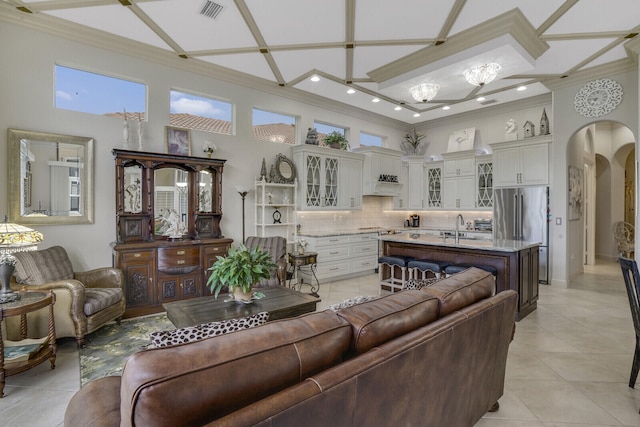 living room with arched walkways, light tile patterned floors, visible vents, and crown molding