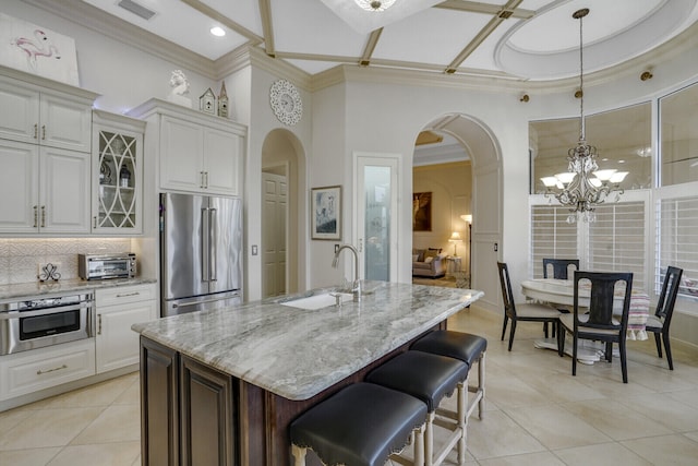 kitchen featuring stainless steel appliances, a sink, glass insert cabinets, and white cabinets