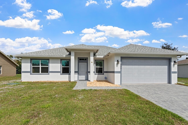 1825 SW Effland Ave, Port Saint Lucie, FL 34953 - prairie-style home with stucco siding, an attached garage, decorative driveway, and a front lawn