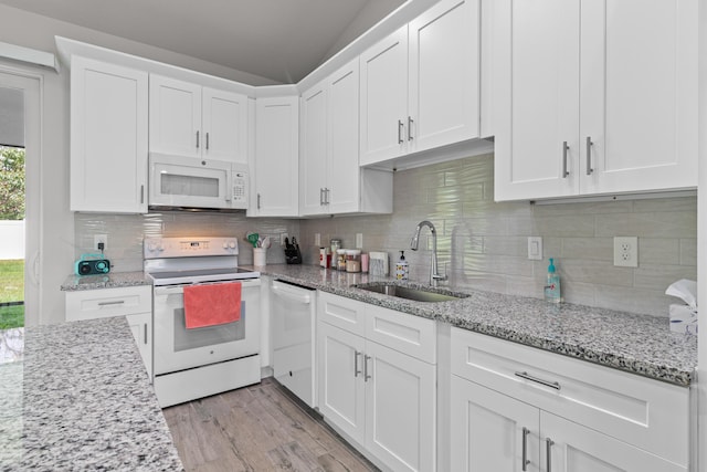 1825 SW Effland Ave, Port Saint Lucie, FL 34953 - kitchen with white appliances, a sink, white cabinets, and light wood-style floors