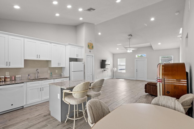 1825 SW Effland Ave, Port Saint Lucie, FL 34953 - kitchen with white appliances, a sink, open floor plan, a kitchen breakfast bar, and decorative backsplash