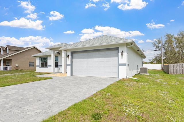 view of front of home featuring a front yard, a garage, and central air condition unit