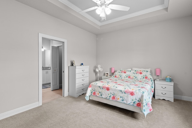 1825 SW Effland Ave, Port Saint Lucie, FL 34953 - carpeted bedroom featuring a tray ceiling, ornamental molding, baseboards, ensuite bath, and ceiling fan