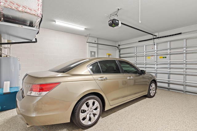 1825 SW Effland Ave, Port Saint Lucie, FL 34953 - garage featuring a garage door opener, water heater, and concrete block wall