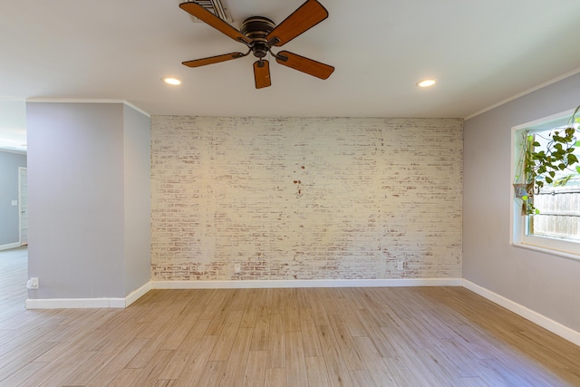 empty room featuring light wood-type flooring, ceiling fan, brick wall, and ornamental molding