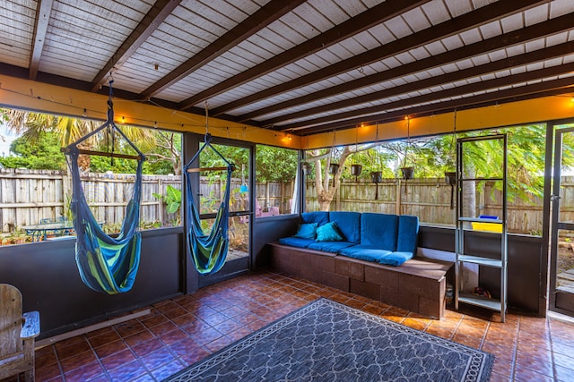 unfurnished sunroom featuring beamed ceiling