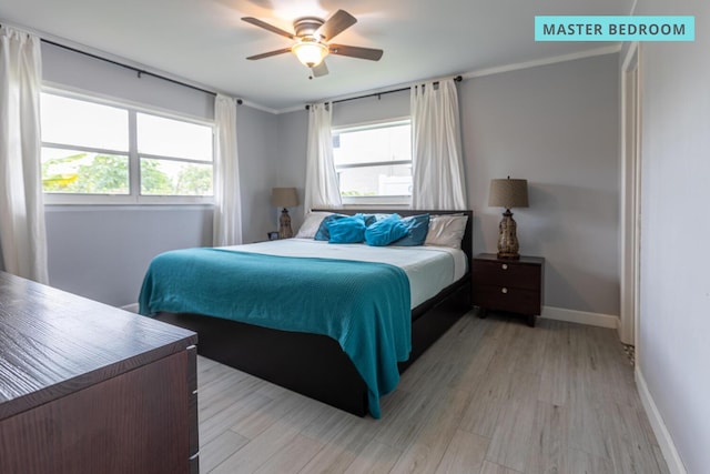 bedroom featuring light wood-style floors, multiple windows, baseboards, and a ceiling fan