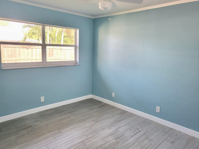 spare room featuring ornamental molding, ceiling fan, baseboards, and wood finished floors