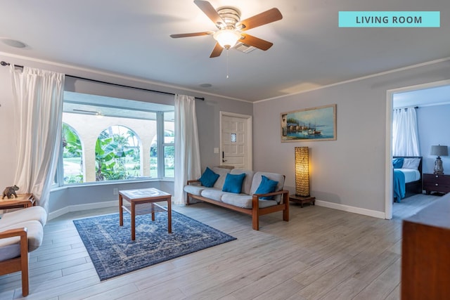 living area featuring light wood-type flooring, crown molding, baseboards, and a ceiling fan