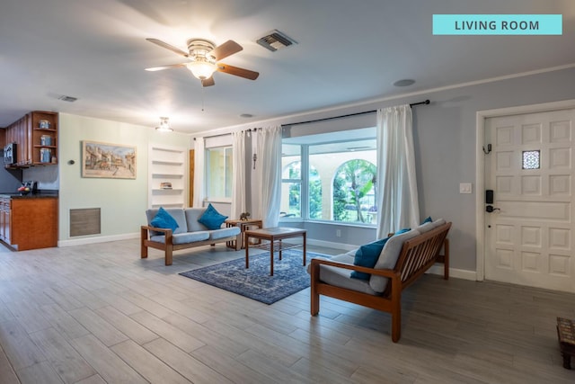 living room featuring light wood-type flooring, ceiling fan, and built in features