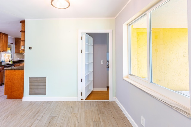 unfurnished room featuring light wood-type flooring, a wealth of natural light, and visible vents