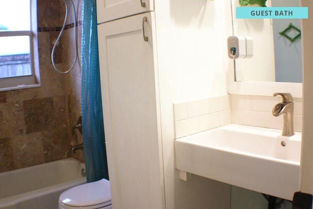 bathroom featuring shower / tub combo, a sink, and toilet