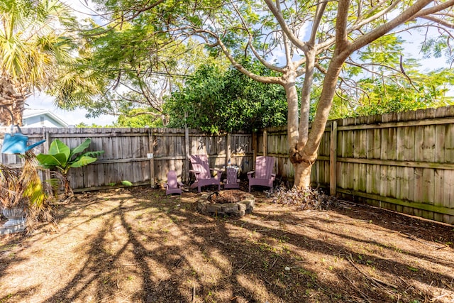 view of yard with a fenced backyard and a fire pit