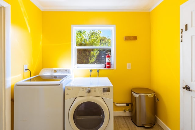 clothes washing area with separate washer and dryer and wood-type flooring