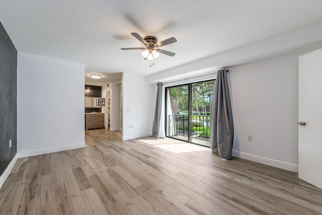 interior space with baseboards, a ceiling fan, and light wood-style floors