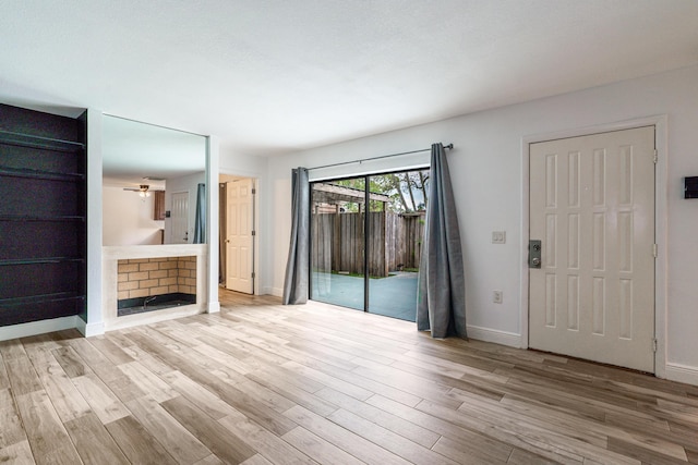 unfurnished living room featuring light wood finished floors and baseboards