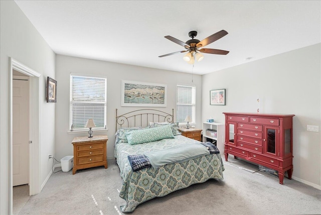 bedroom with multiple windows, ceiling fan, and light colored carpet